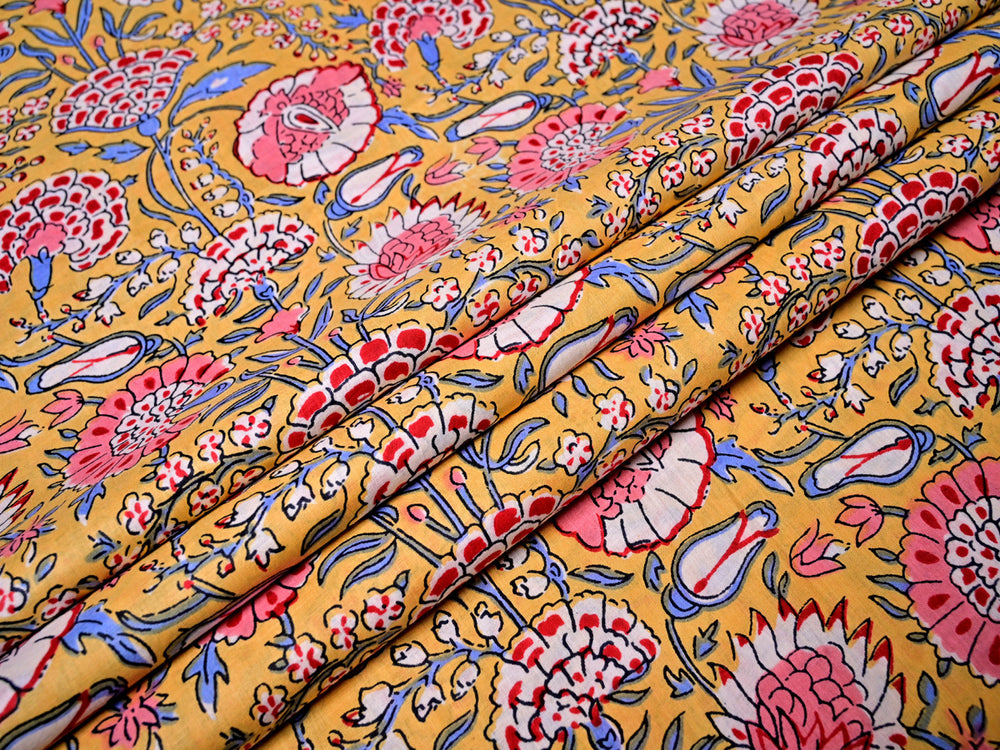 Close-up of red floral print cotton fabric, ideal for sewing tote bags and cushion covers.