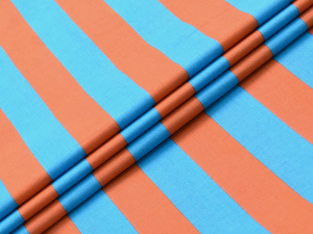 Flat lay photo of turquoise and orange vertical stripe fabric showing the repeat pattern.
