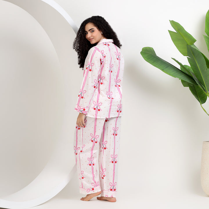 Women wearing Women's Organic Cotton Holiday Pajama Set, featuring white and pink bow print, showcasing comfort and style.