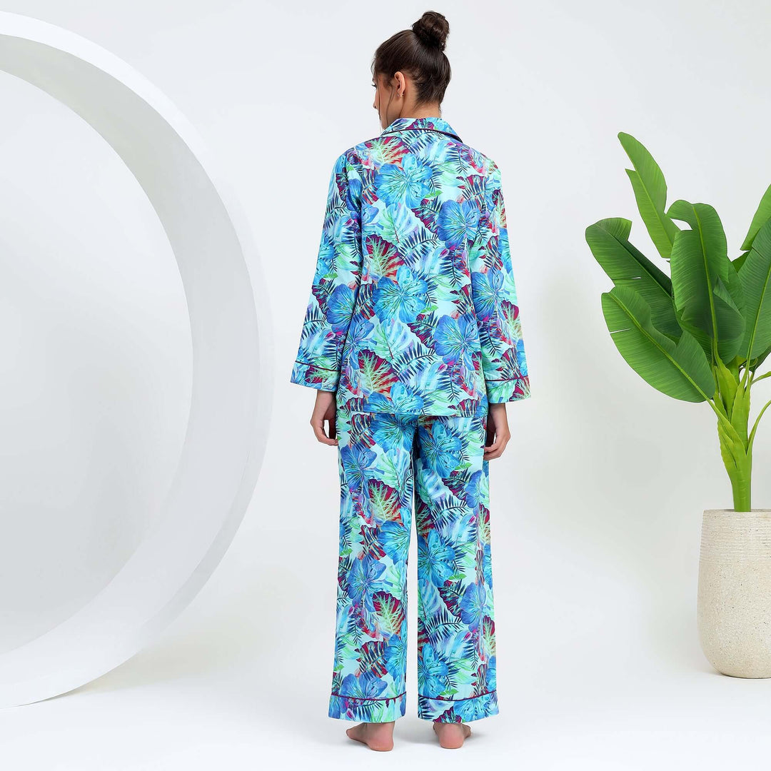 Back view of a woman wearing tropical floral cotton pajamas, showcasing the colorful leaf print design.