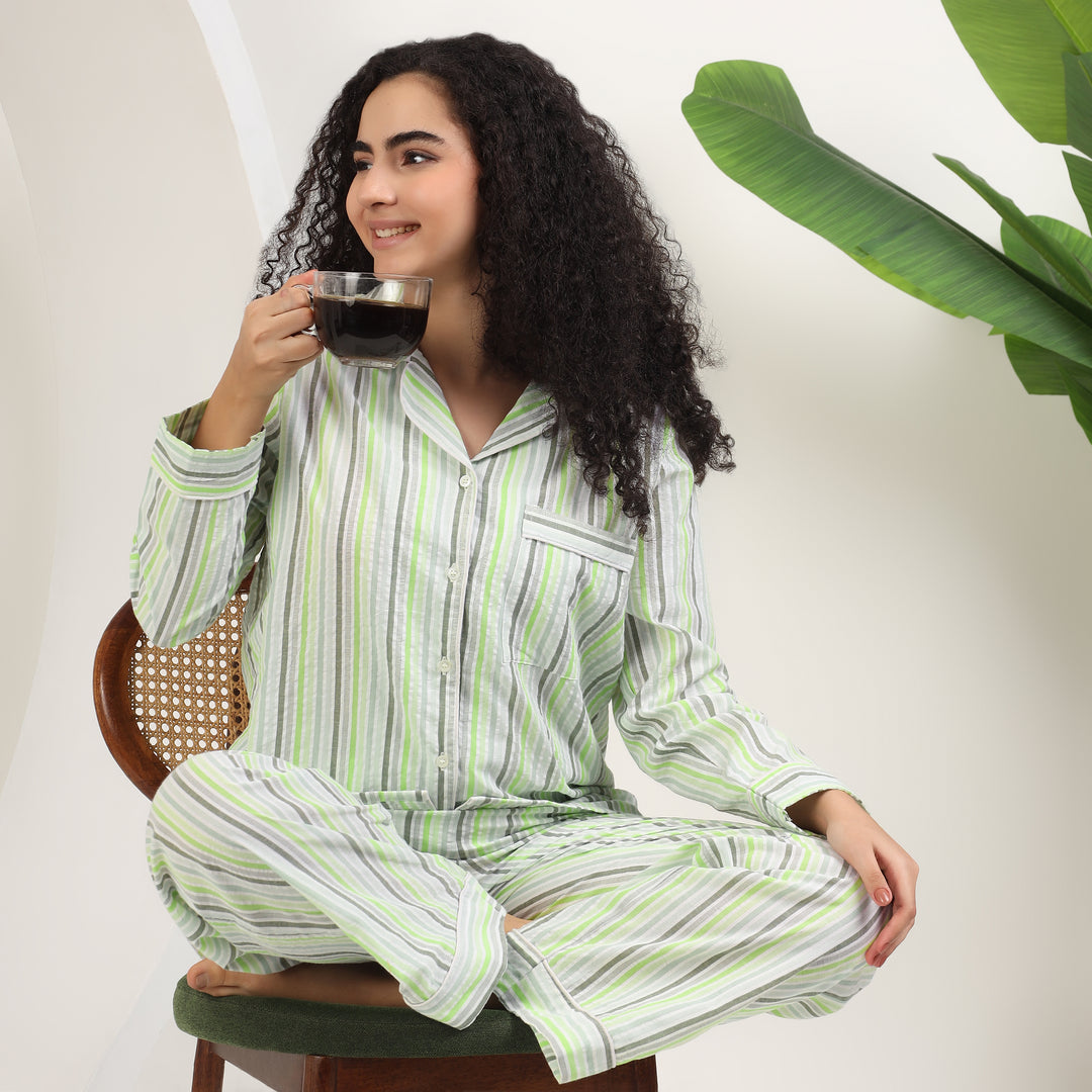 womens family matching cotton striped pajamas in green and white, model enjoying coffee in cozy setting.