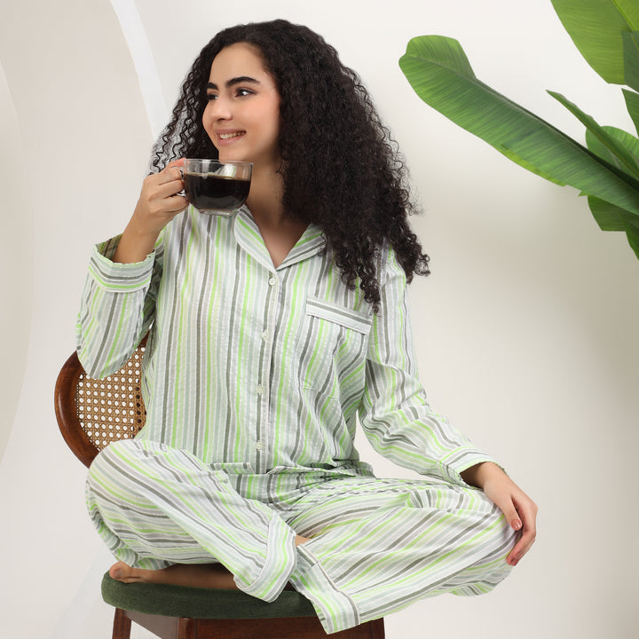 womens family matching cotton striped pajamas in green and white, model enjoying coffee in cozy setting.