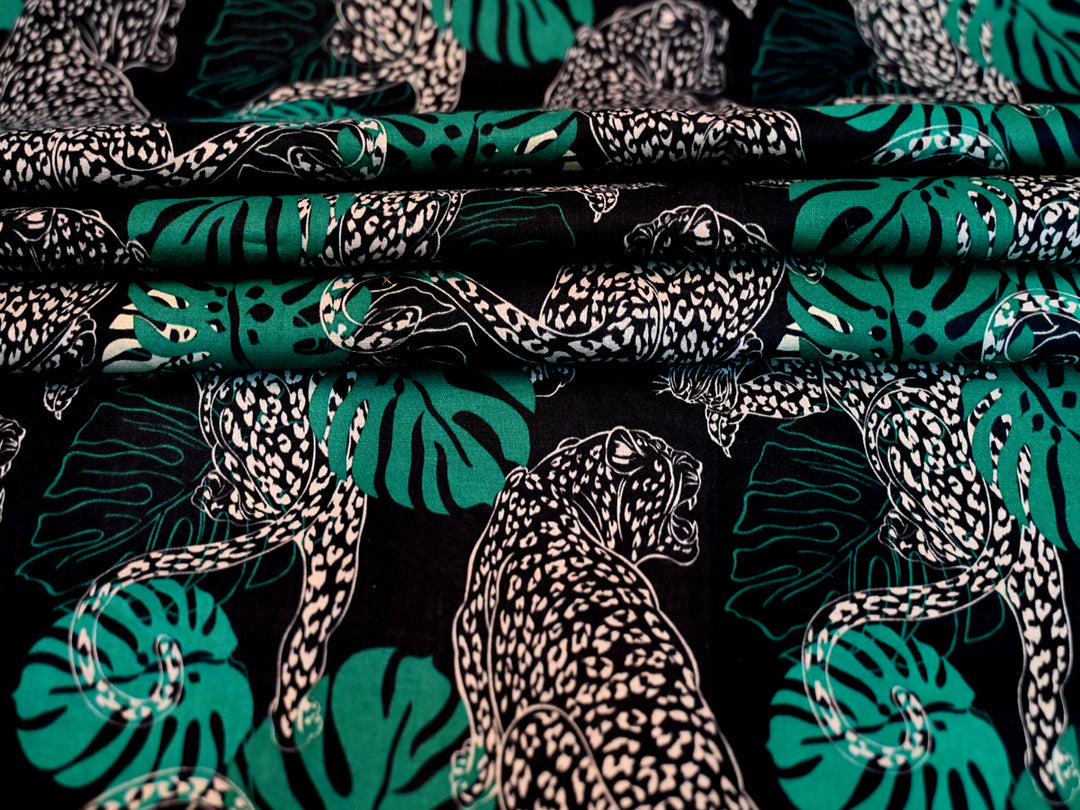 Fabric with leopard and leaf pattern on a black background