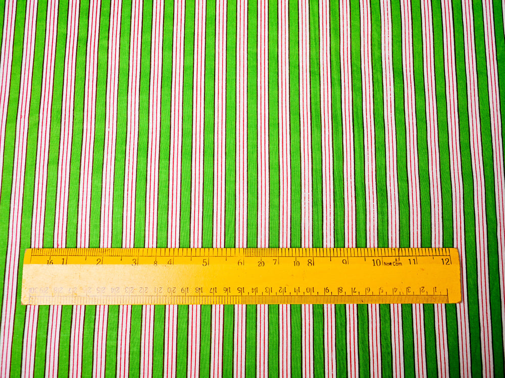 Close-up of green croquet stripe fabric with smooth cotton texture.