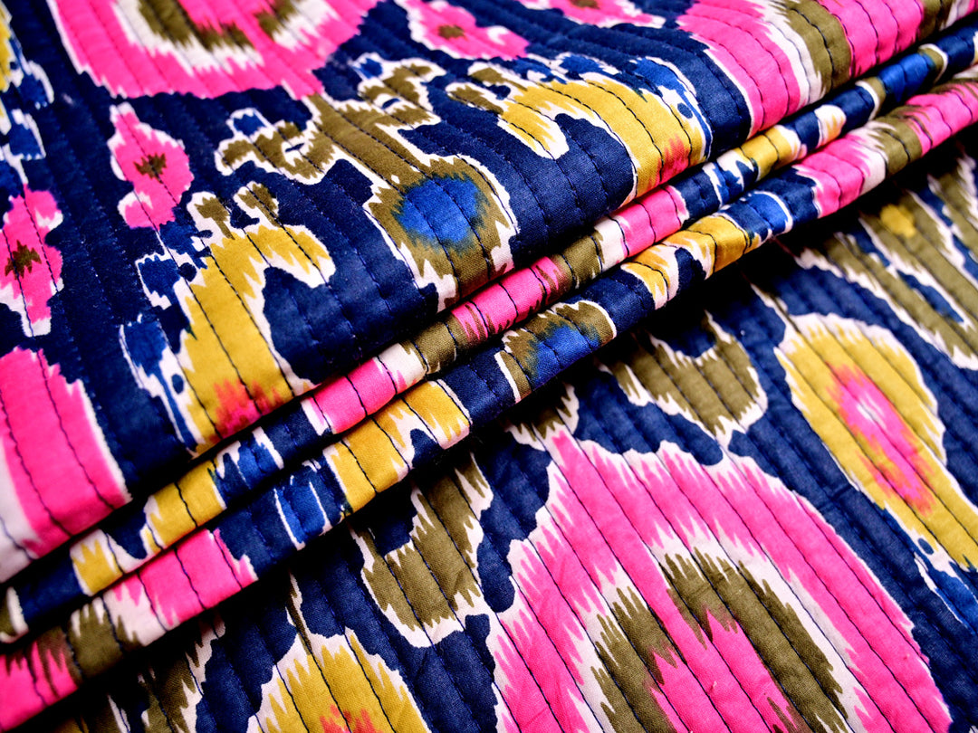 Premium quilted fabric with a vibrant blue ikat pattern, 100% cotton and perfect for creative designs.