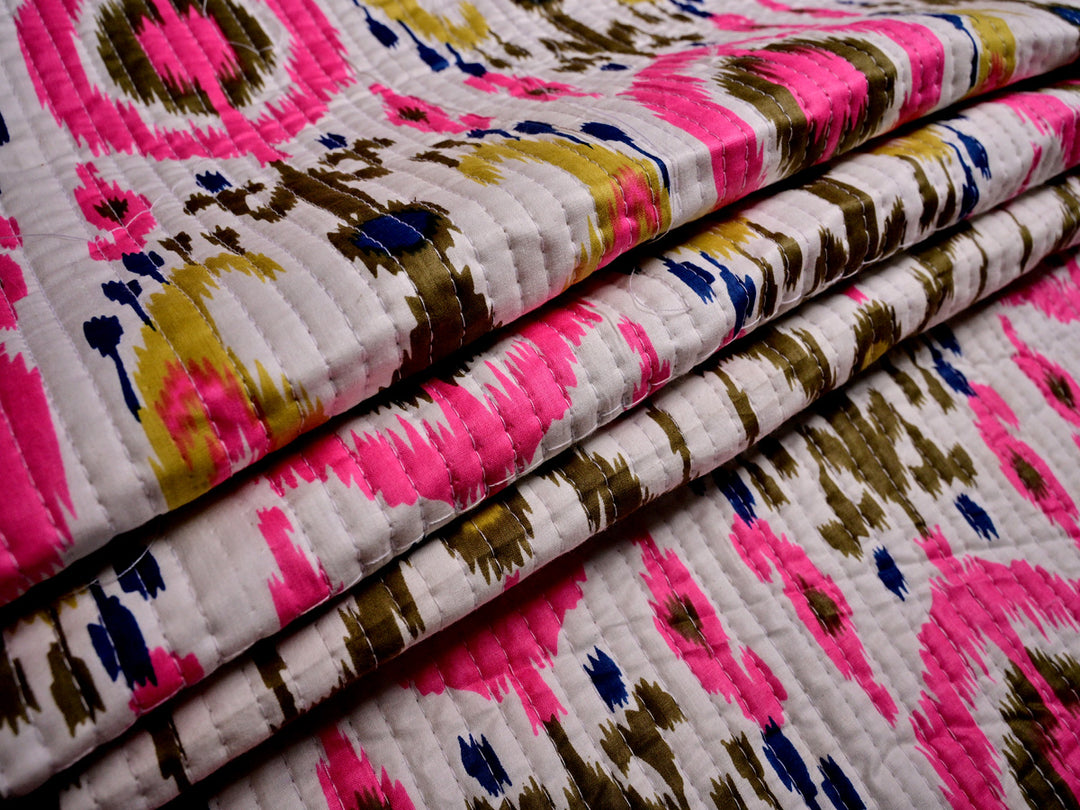 Stylish quilted cotton fabric in a white ikat design, sold by the yard, perfect for jackets and decorative cushions.