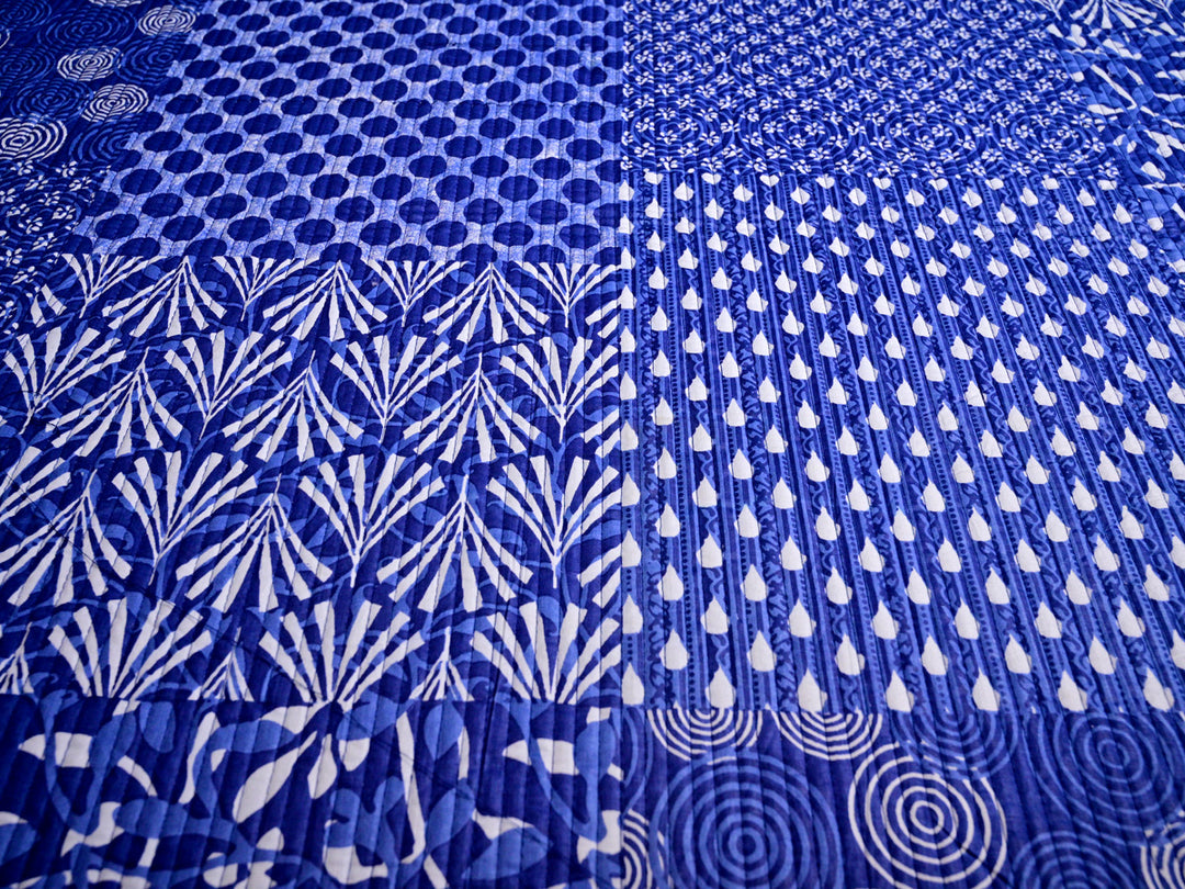 Pre-quilted blue patchwork design fabric in 100% cotton, sold by the yard for creative projects.