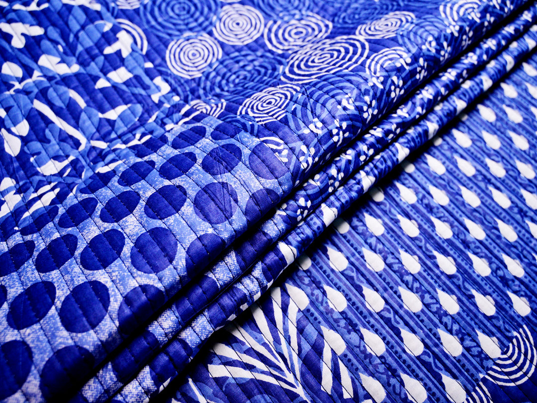 Soft indigo blue cotton quilt fabric with a patchwork design, ideal for crafting, bedding, and upholstery.