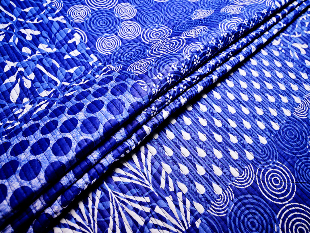 blue cotton fabric featuring a stylish patchwork quilt design, perfect for sewing and quilting.