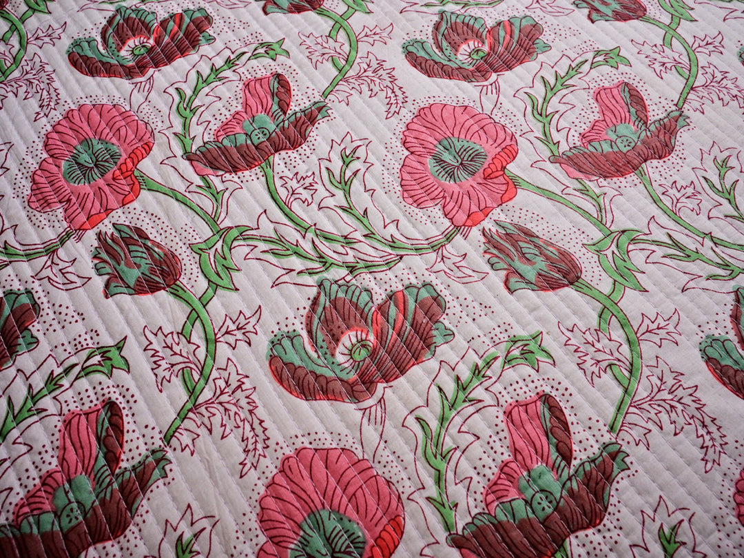 Pre-quilted pink fabric with floral block print design, lightweight and breathable cotton, ideal for crafts and décor.