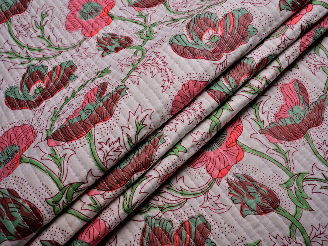 High-quality pink floral quilted material made from pure cotton, ideal for jackets, bedding, and handmade décor projects.