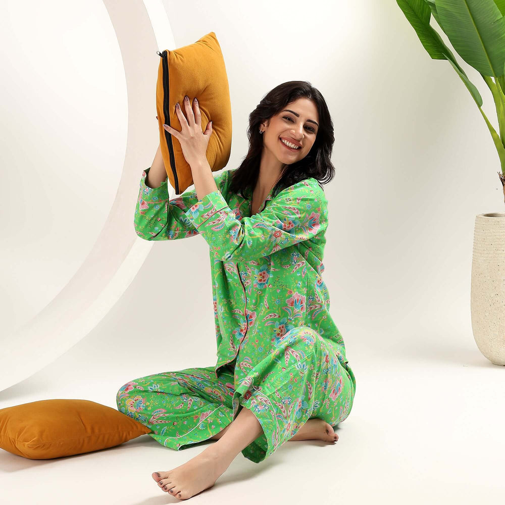 A woman wearing Indian Block Print Floral Cotton Pajamas for Womens, sitting with a pillow, smiling.
