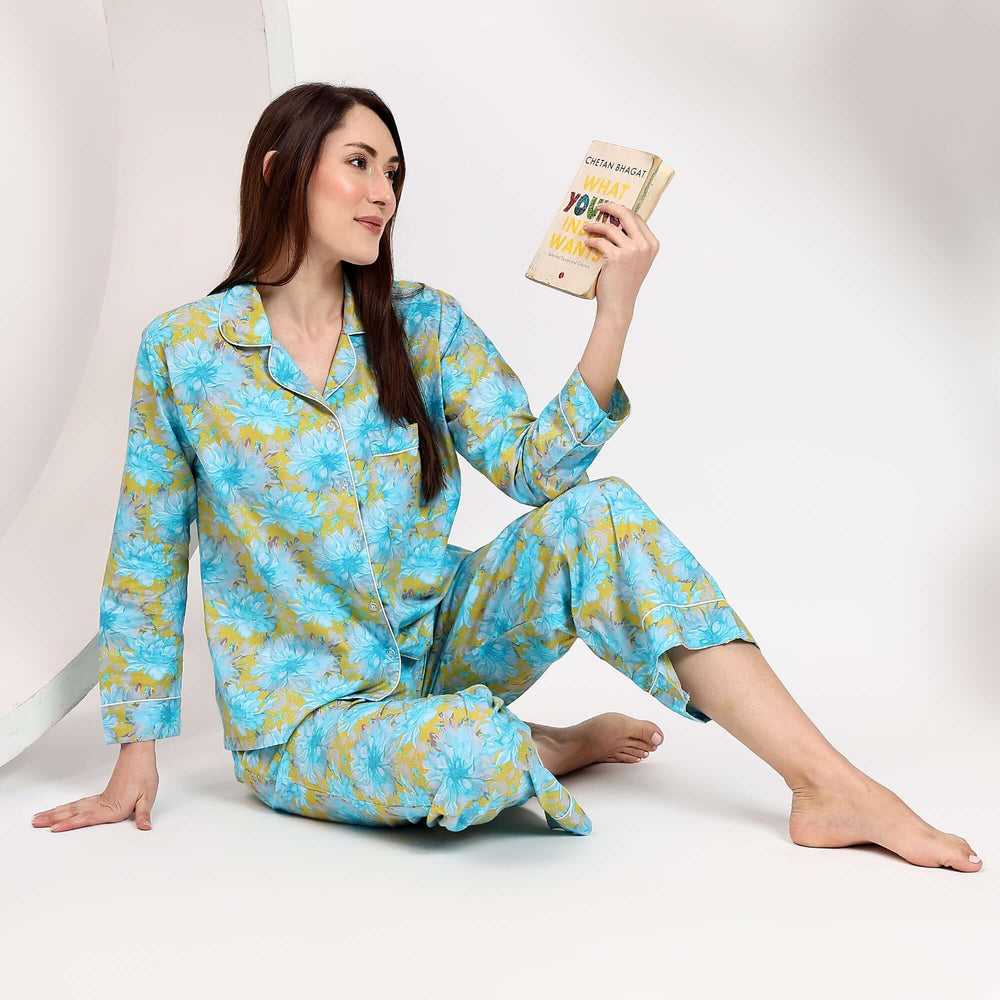 Woman wearing family matching block print pajamas, holding a book, showcasing the vibrant floral design.