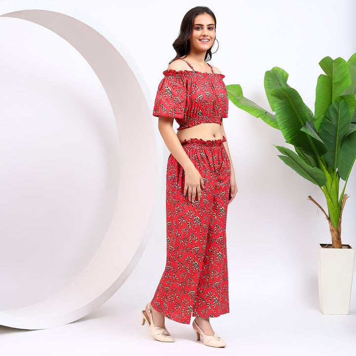 Side profile showcasing the chic red shoulder-baring top and flowy palazzo pants, ideal for a trendy evening outfit.