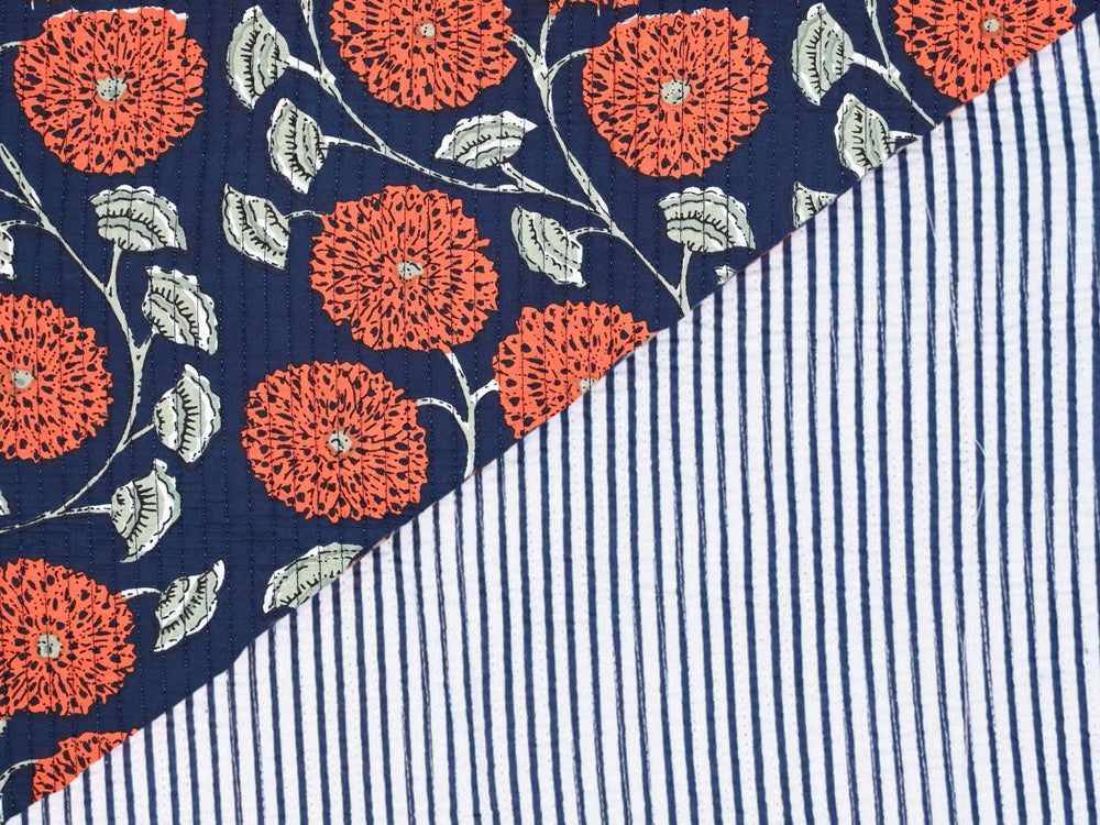 Navy blue cotton quilting fabric with orange floral pattern and white leaves