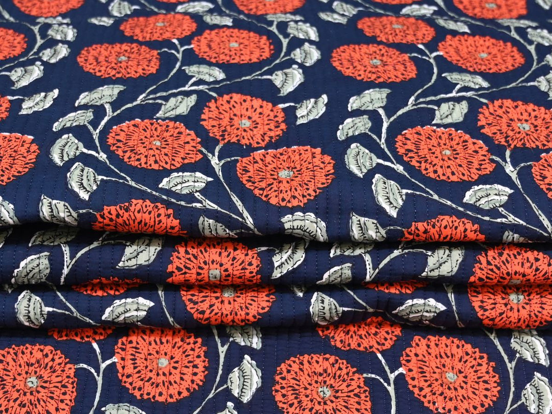 Navy blue floral quilting cotton folded showing quilted texture and stitching