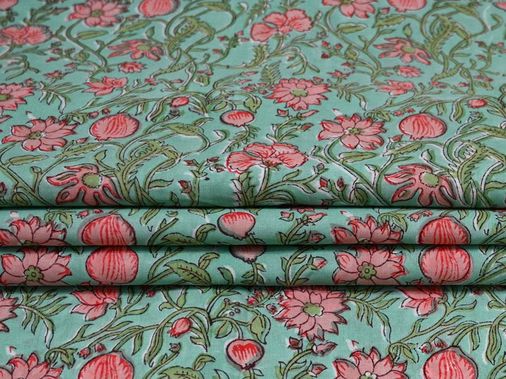 Floral fabric with pink flowers on a teal background