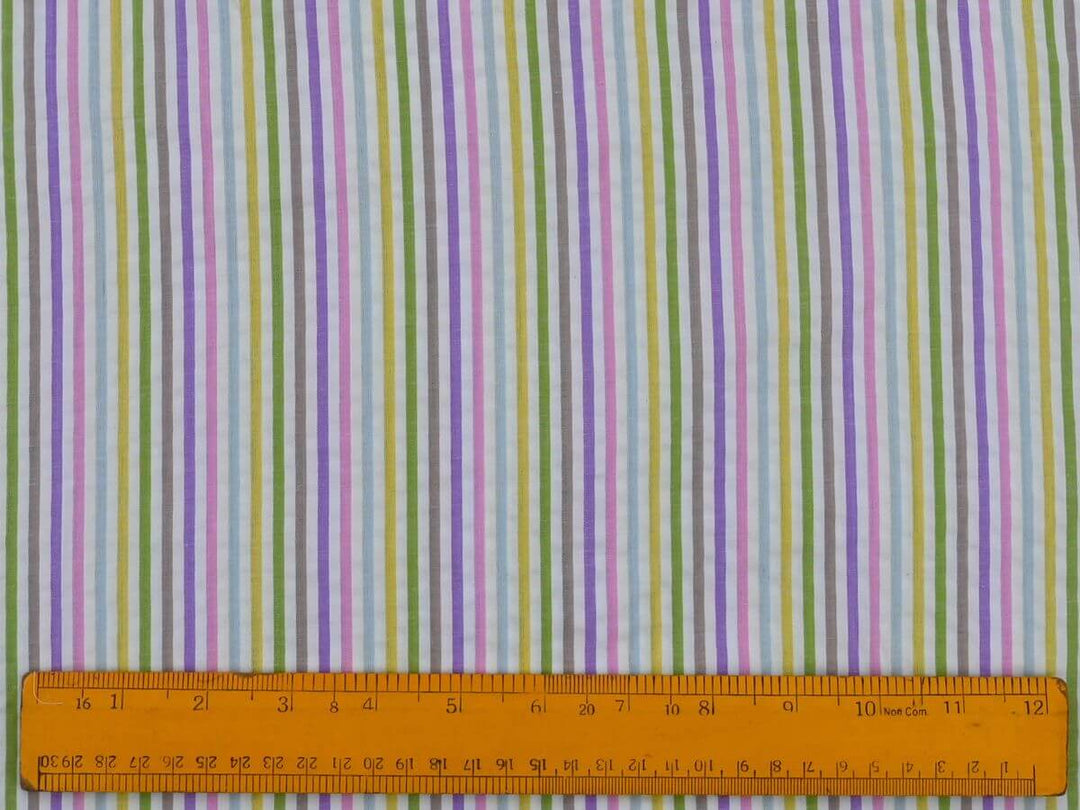 Woven stripe cotton fabric by the yard displayed with a ruler for scale, featuring vibrant pastel stripes.