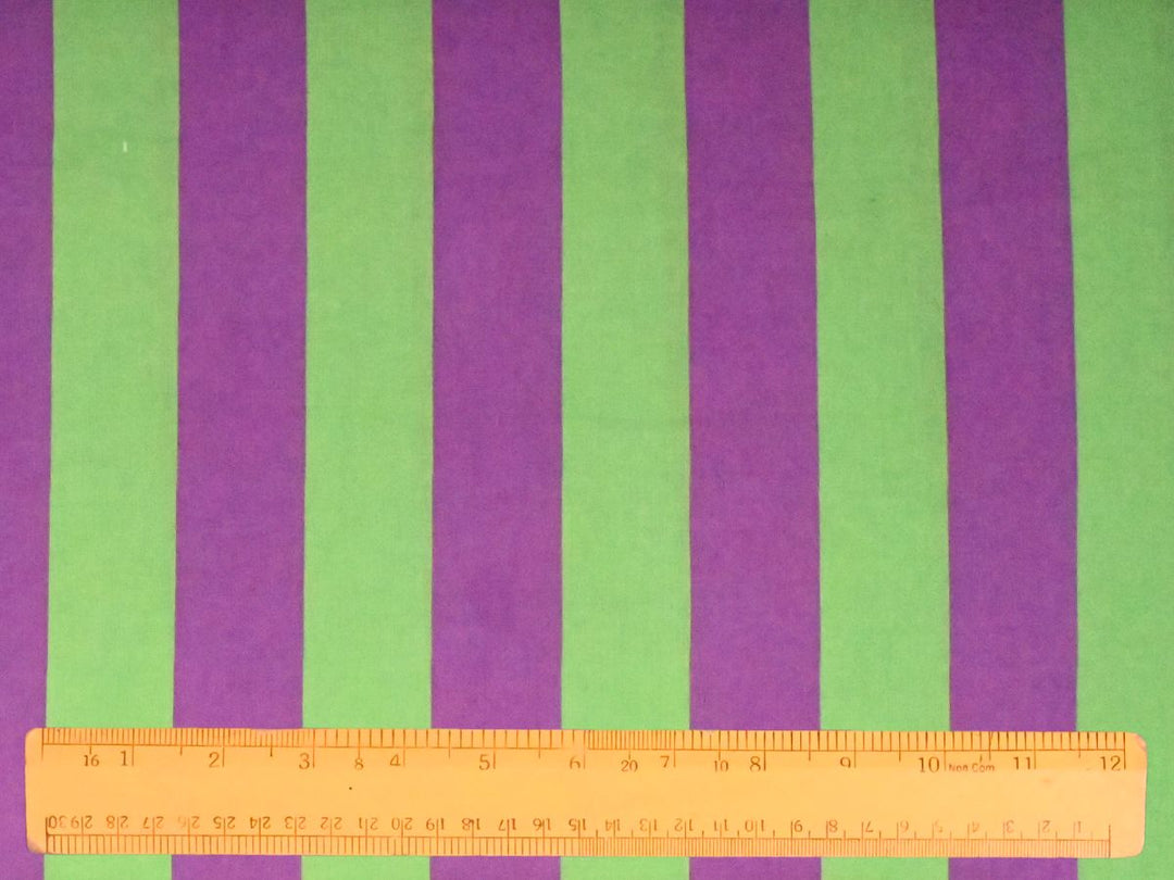 Softly layered folds of Indolibas purple and green printed stripe fabric showing its lightweight drape.