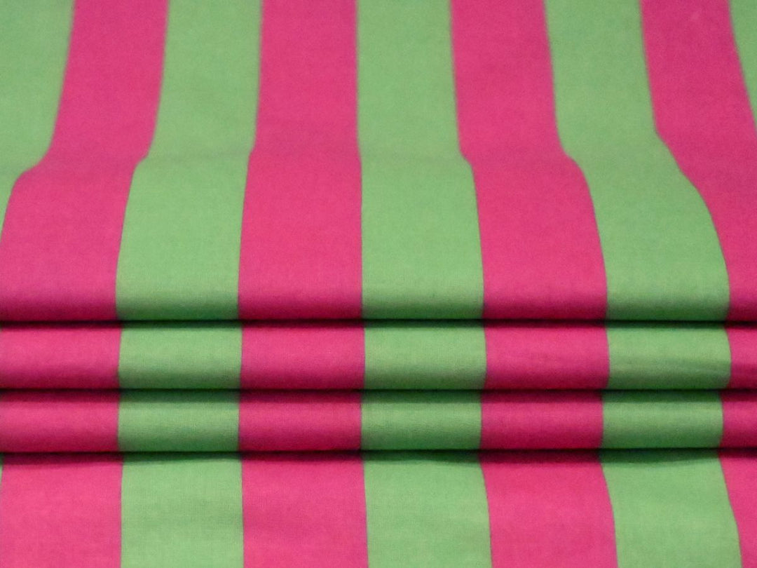 Indolibas green and pink printed cotton fabric shown against light to demonstrate its lightweight construction.