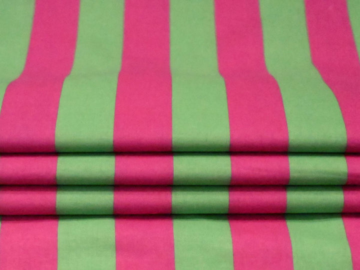 Indolibas green and pink printed cotton fabric shown against light to demonstrate its lightweight construction.