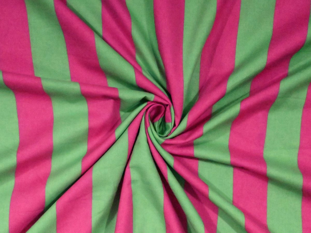 Softly folded Indolibas pink and green vertical stripe printed fabric showing its lightweight drape.