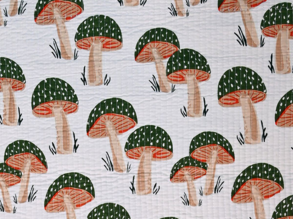 White quilted cotton fabric with green orange and beige mushroom print