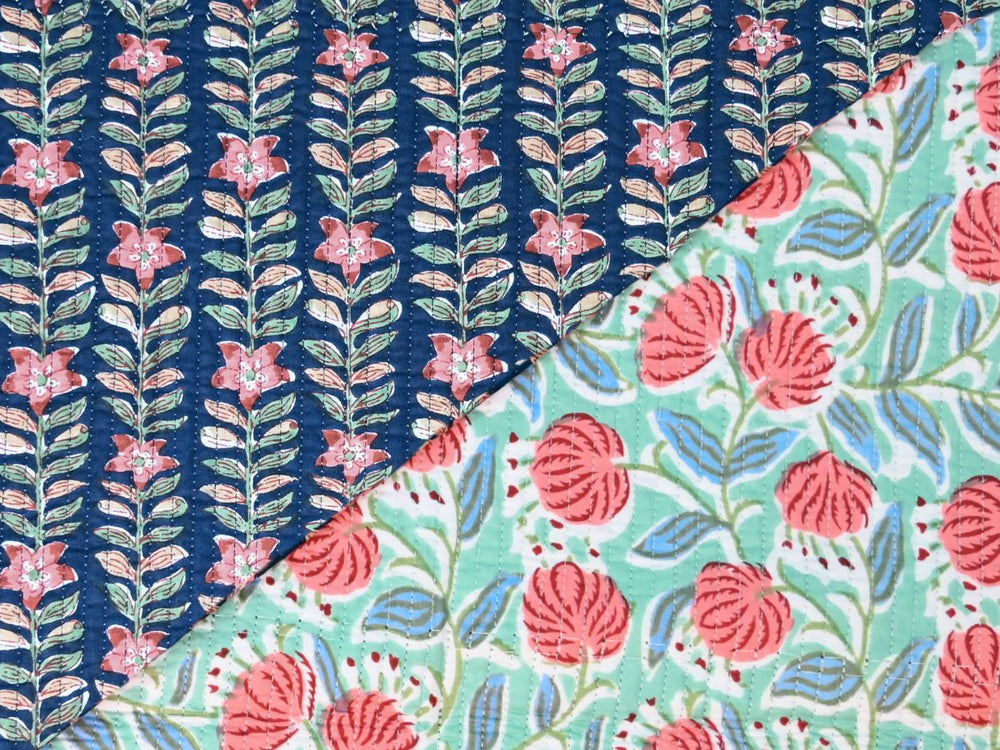 Navy blue quilted cotton fabric with pink flowers and green leaves