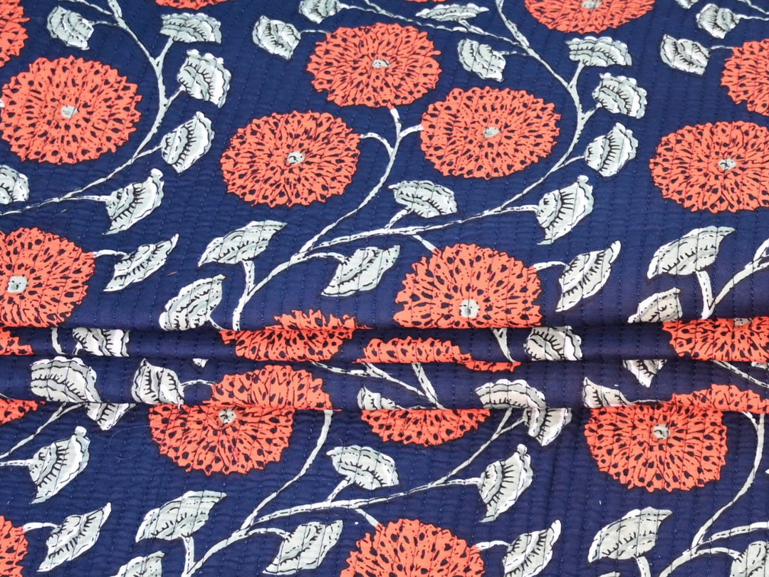 Navy blue floral quilting cotton folded showing quilted texture and stitching