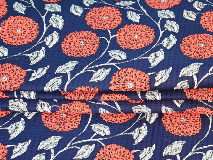 Navy blue floral quilting cotton folded showing quilted texture and stitching