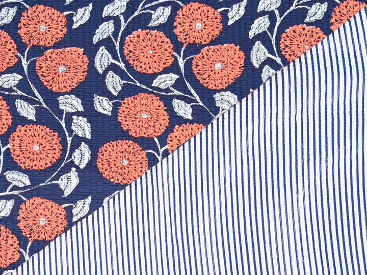 Navy blue cotton quilting fabric with orange floral pattern and white leaves