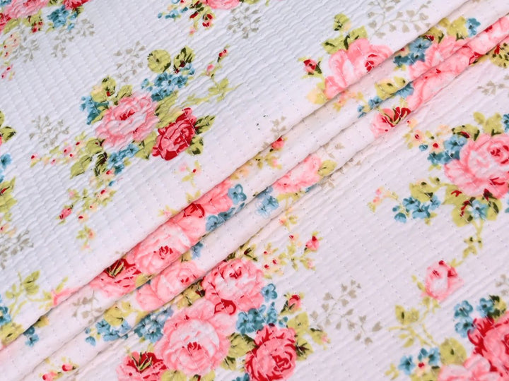 Pink floral quilted fabric with vintage roses and blue floral accents