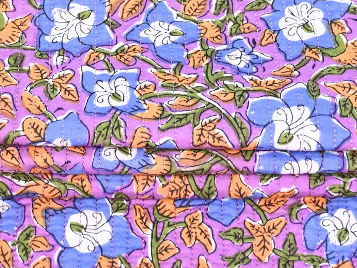 Folded purple floral quilted fabric showing texture and stitching
