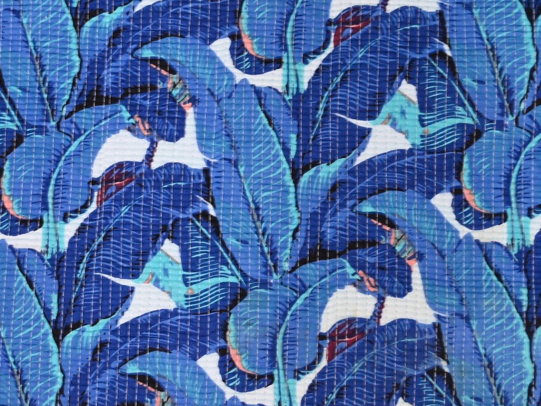Blue tropical leaf quilted fabric showing diagonal stitching detail