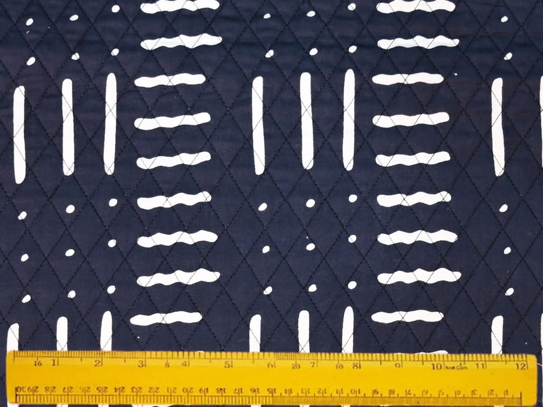 Close-up of white dash and dot quilted fabric on black ground