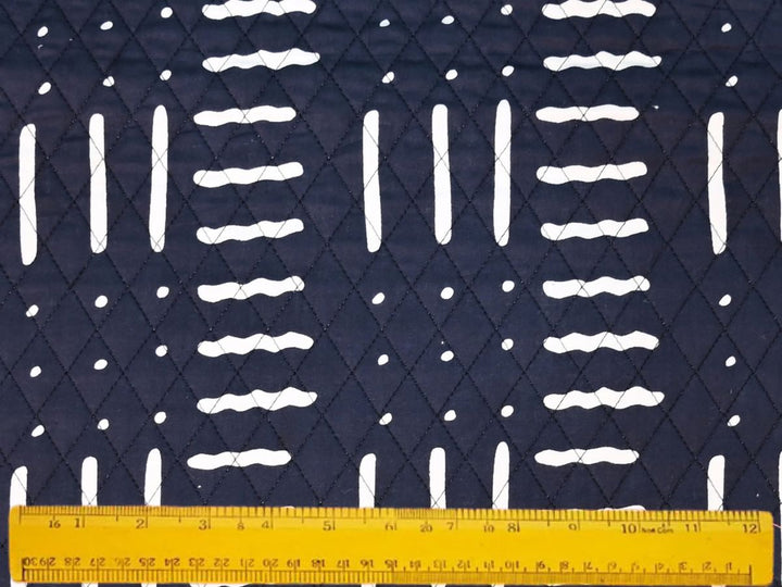 Close-up of white dash and dot quilted fabric on black ground