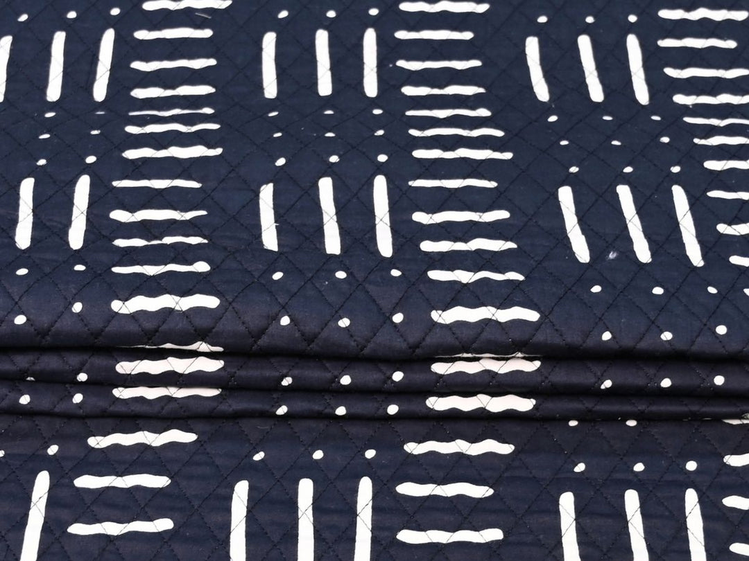 Reversible quilted fabric with pink and white striped reverse on black
