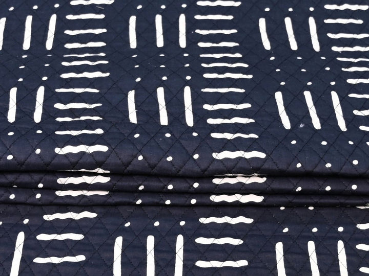 Reversible quilted fabric with pink and white striped reverse on black