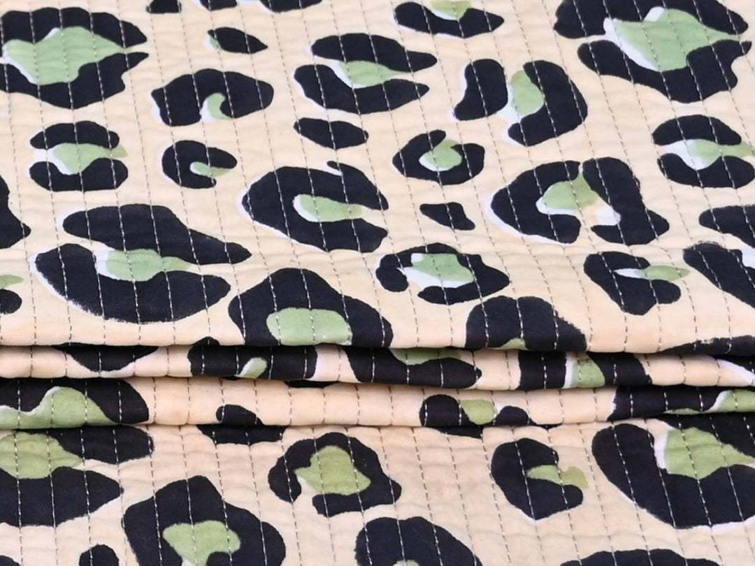 Close-up of green leopard quilted fabric with vertical stitch lines