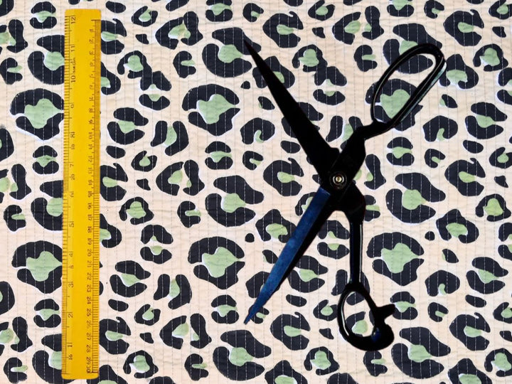 Green leopard quilted fabric showing black spots with sage green centers