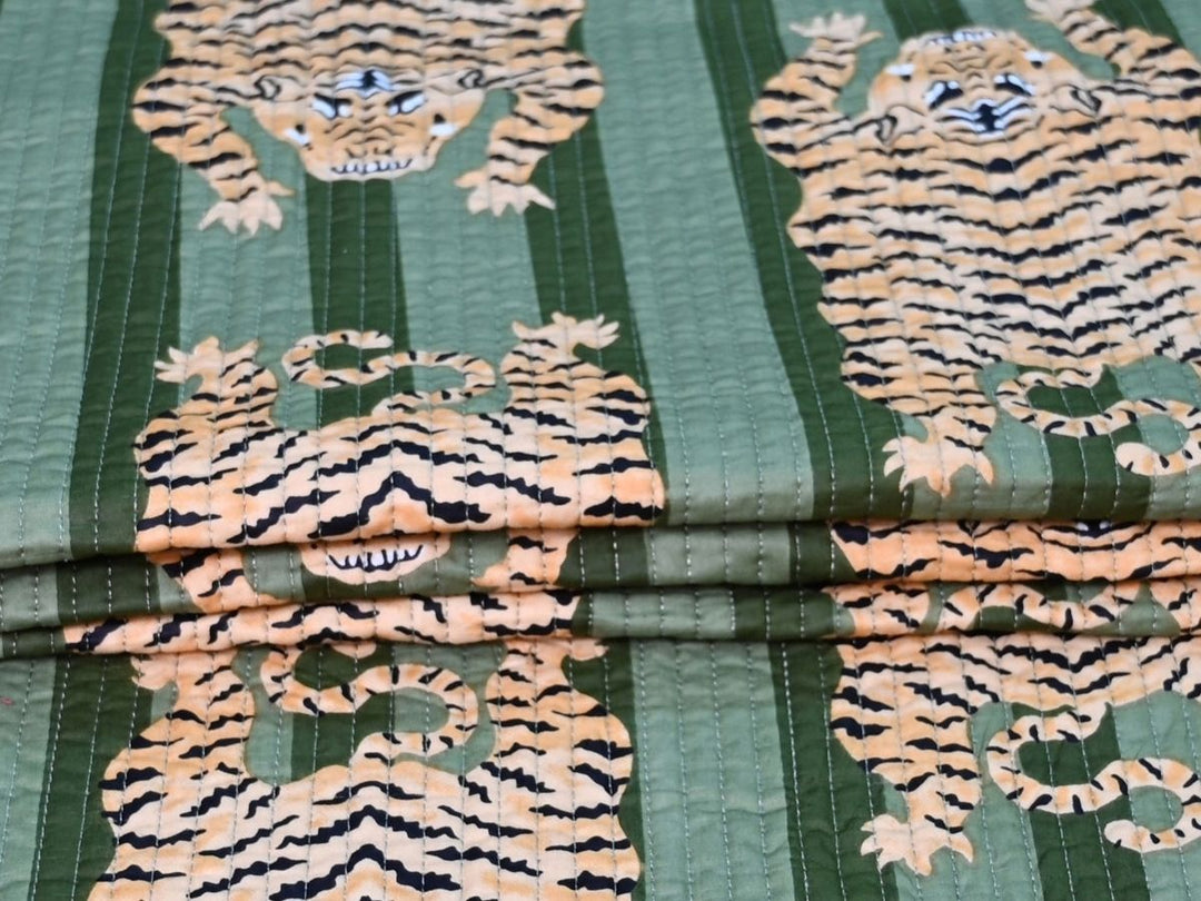 Close-up of tiger print quilted fabric with black stripes and white facial details