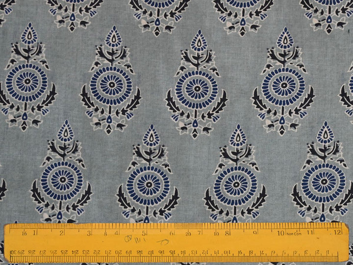 Grey Indian cotton fabric showing blue and white fan-shaped flowers