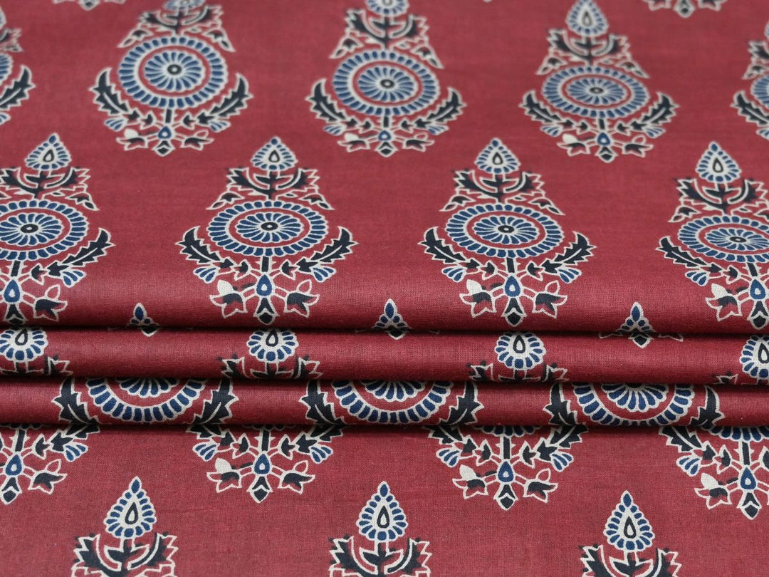 Maroon Bagru block print fabric showing blue fan-shaped flowers