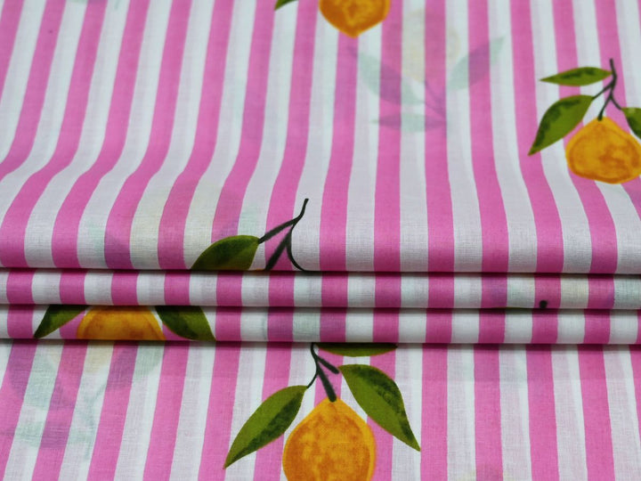 Close-up of pink lemon stripe fabric with yellow lemons and green leaves