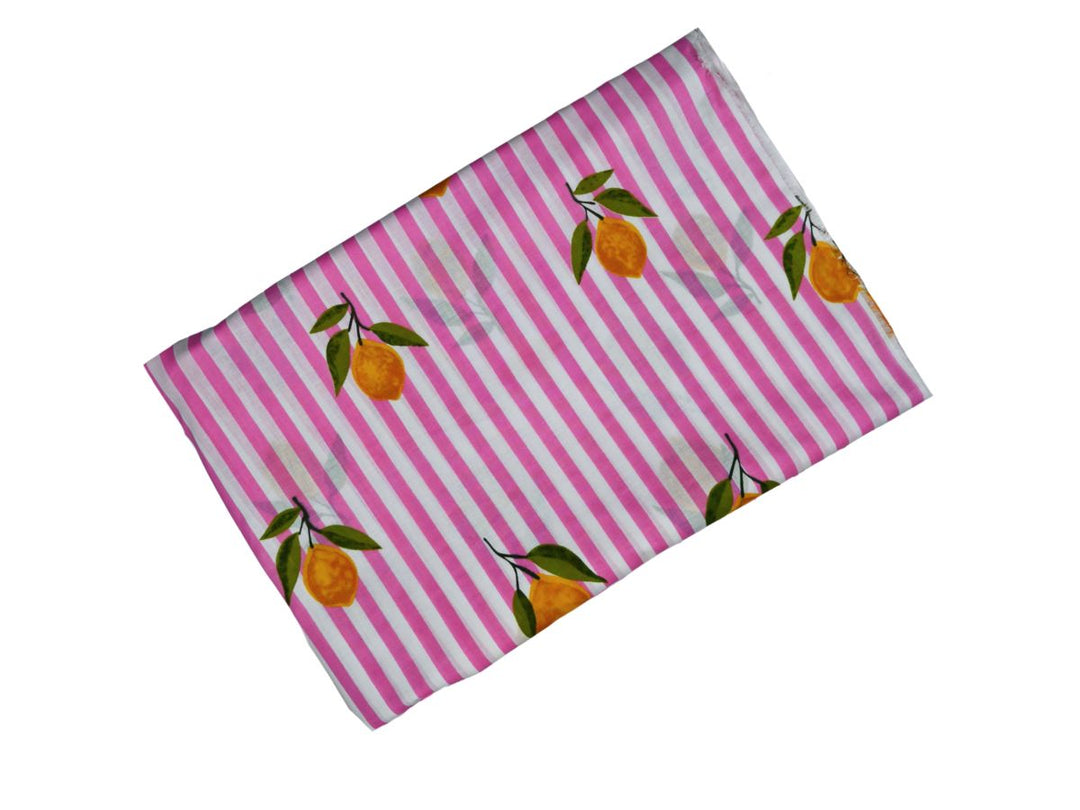 Lemon print cotton fabric showing green leaves on pink stripes