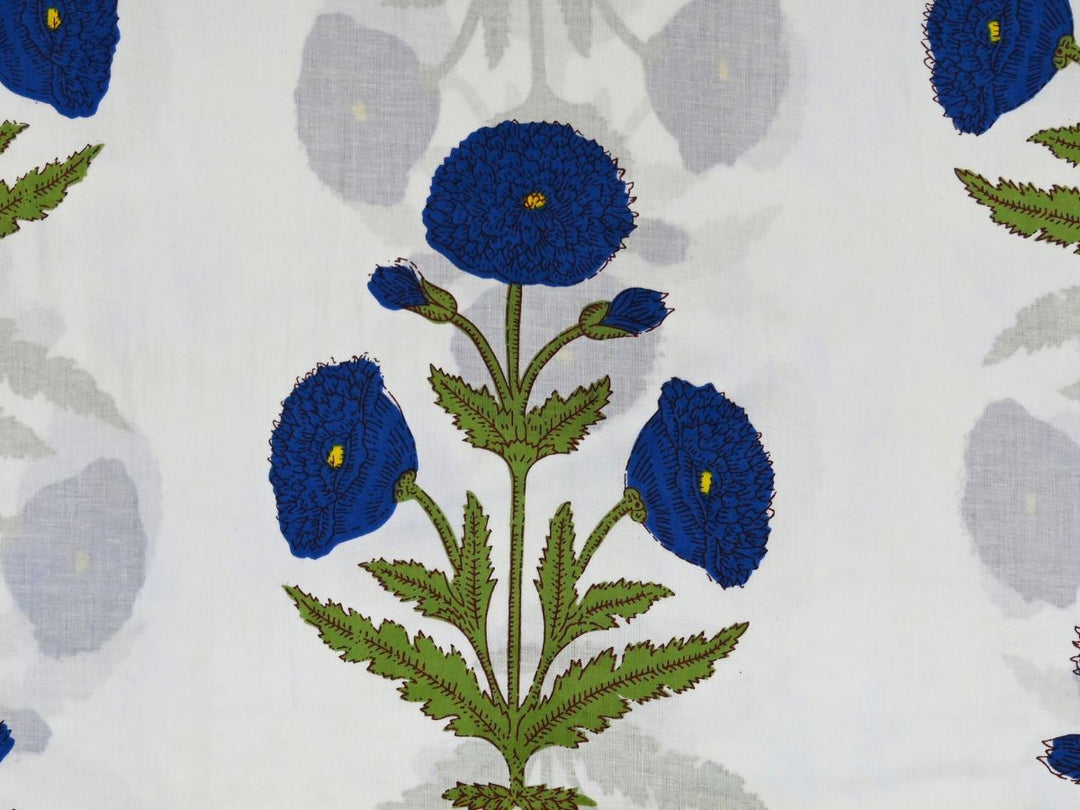Indian block print fabric showing blue floral sprig and green leaves