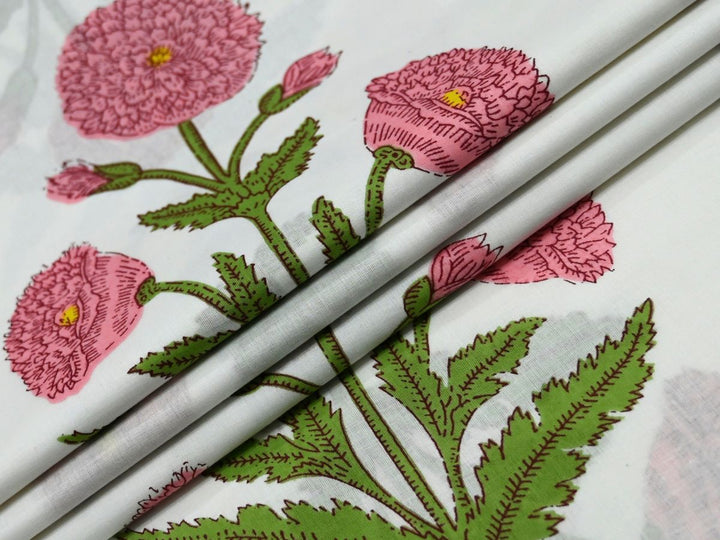 Indian block print fabric showing pink floral sprig and green leaves