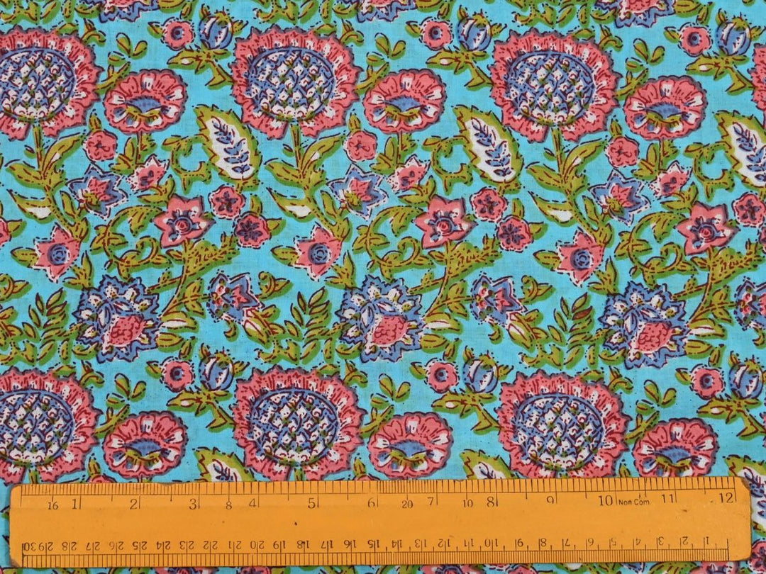 Dense floral block print fabric showing pink and red blossoms