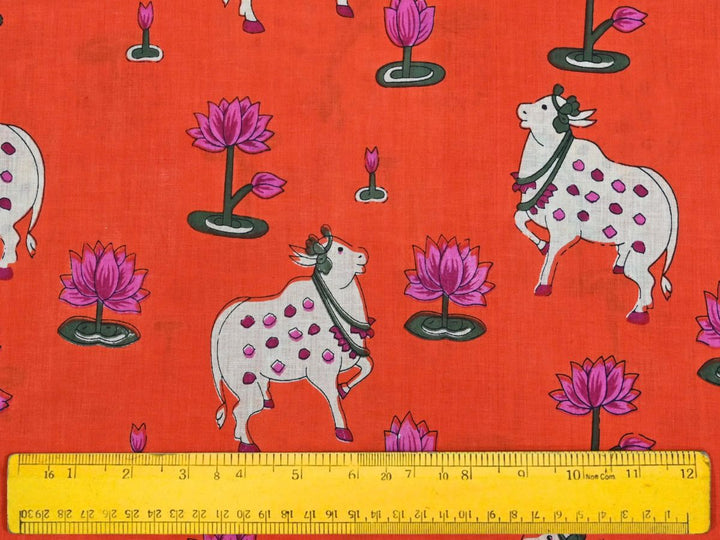 Printed cotton fabric with folk art cow and lotus design on orange ground
