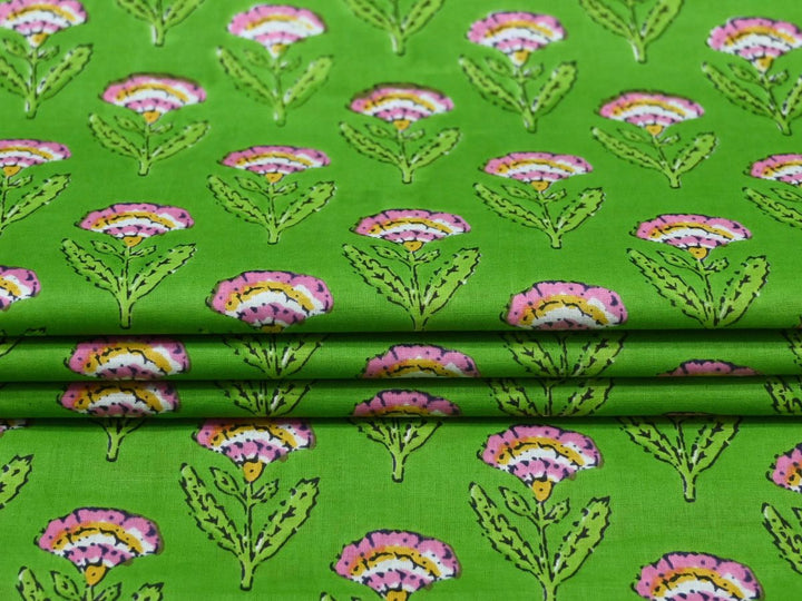 Close-up of green floral block print cotton fabric with pink and yellow details
